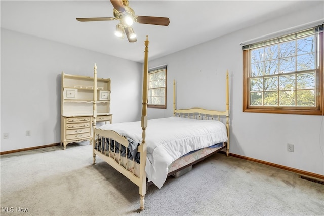 carpeted bedroom featuring baseboards, visible vents, and multiple windows