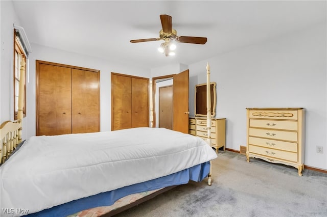 bedroom with baseboards, multiple closets, ceiling fan, and carpet
