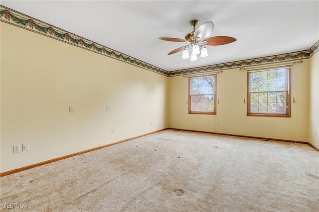 empty room featuring baseboards, carpet flooring, and a ceiling fan
