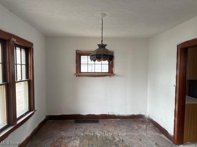 538 Columbus Ave NW, Canton, OH 44708 - unfurnished dining area featuring baseboards, carpet, a healthy amount of sunlight, and visible vents