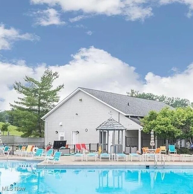 community pool featuring a patio and fence
