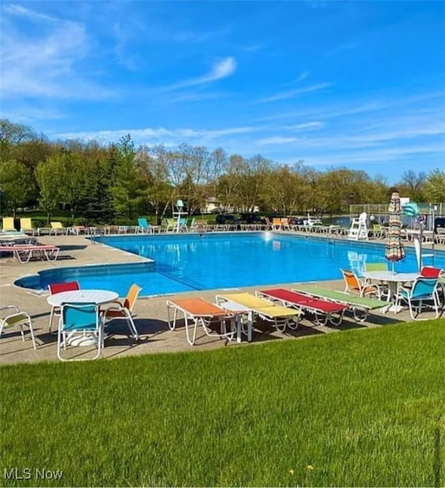 community pool featuring a lawn and a patio