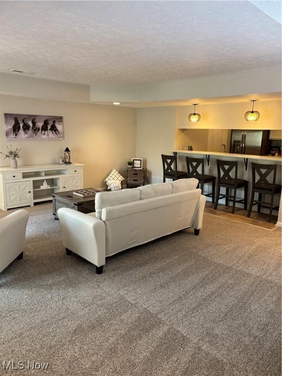 living room featuring carpet floors and a textured ceiling