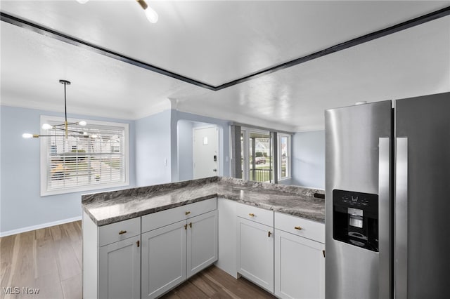 kitchen with pendant lighting, baseboards, dark wood-type flooring, white cabinetry, and stainless steel fridge with ice dispenser