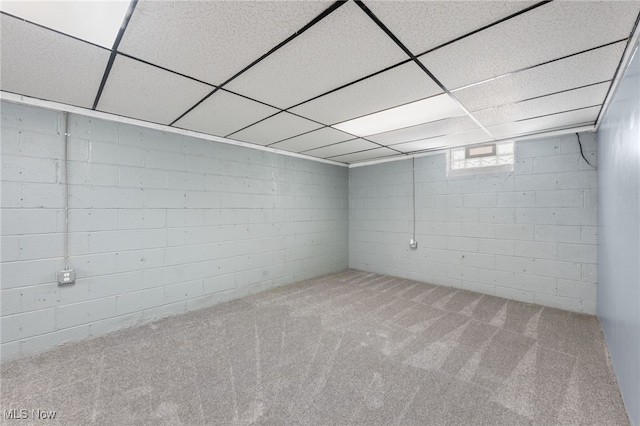 below grade area with carpet flooring and a paneled ceiling