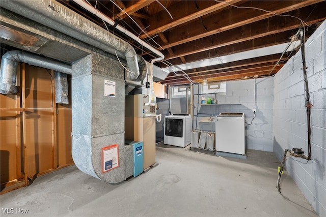 basement featuring heating unit and washing machine and clothes dryer