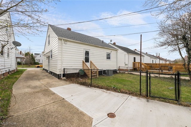 back of house featuring a yard, fence, a gate, and entry steps