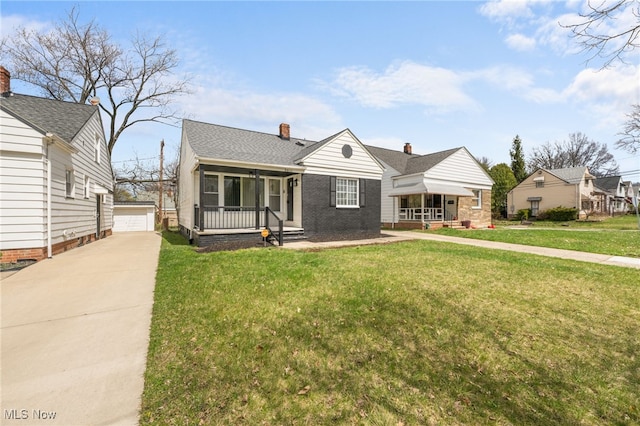 bungalow-style home featuring a detached garage, a front yard, an outbuilding, a chimney, and covered porch