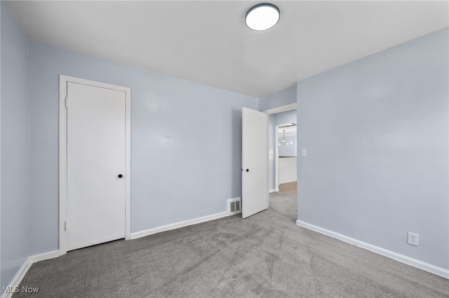 carpeted spare room featuring visible vents and baseboards