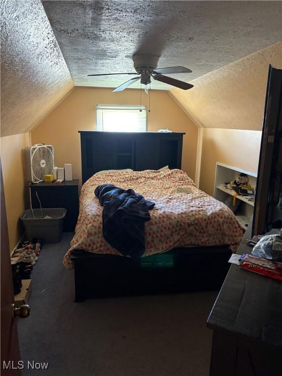 carpeted bedroom with ceiling fan, a textured ceiling, and lofted ceiling