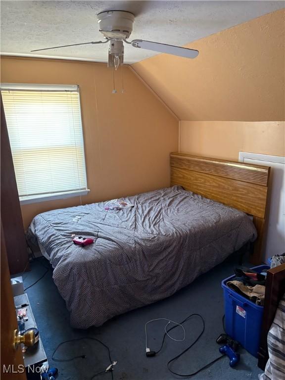 bedroom with a ceiling fan and lofted ceiling