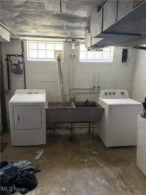 laundry area featuring independent washer and dryer, laundry area, and a sink