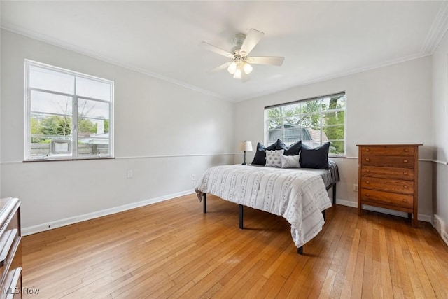 bedroom featuring light wood-style floors, baseboards, crown molding, and ceiling fan