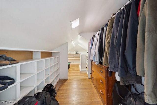 spacious closet featuring light wood-style floors and vaulted ceiling