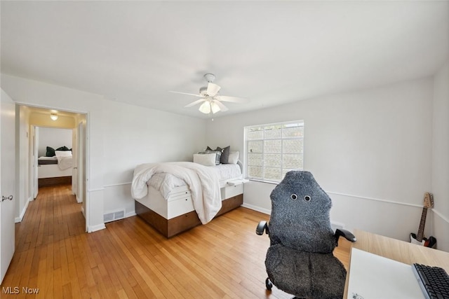 bedroom with visible vents, a ceiling fan, light wood-style flooring, and baseboards