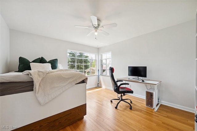 bedroom featuring baseboards, a ceiling fan, and light wood-style flooring