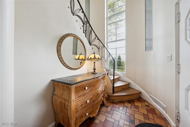interior space featuring baseboards, brick floor, and visible vents