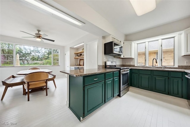 kitchen with ceiling fan, appliances with stainless steel finishes, a sink, green cabinetry, and white cabinetry