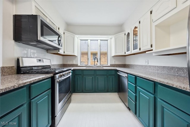kitchen with open shelves, a sink, white cabinets, glass insert cabinets, and stainless steel appliances