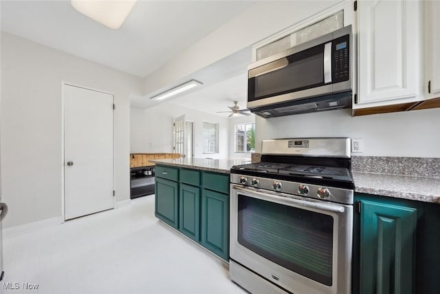 kitchen with appliances with stainless steel finishes, green cabinetry, ceiling fan, and white cabinetry