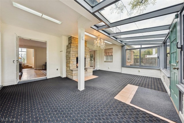 unfurnished sunroom with an inviting chandelier and a skylight
