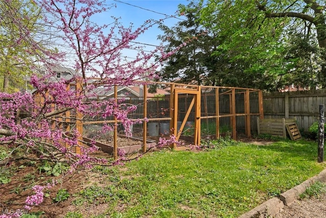 view of yard with exterior structure, fence, and an outbuilding