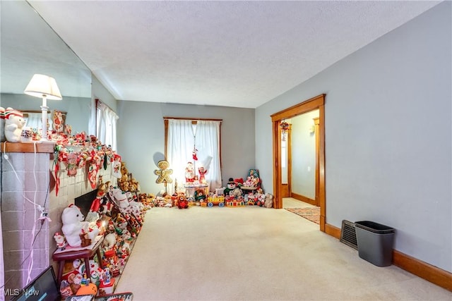 game room featuring carpet floors, a textured ceiling, and baseboards