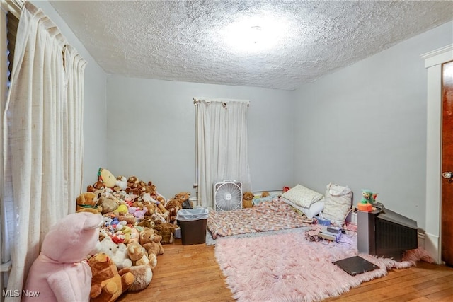 bedroom featuring a textured ceiling and wood finished floors