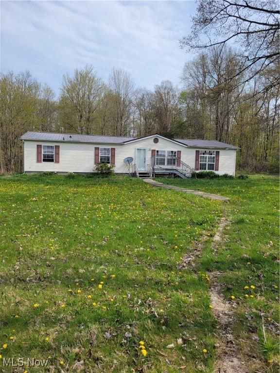 manufactured / mobile home featuring a deck and a front yard