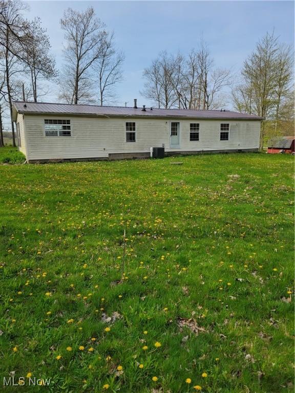 back of house featuring a lawn and central AC unit