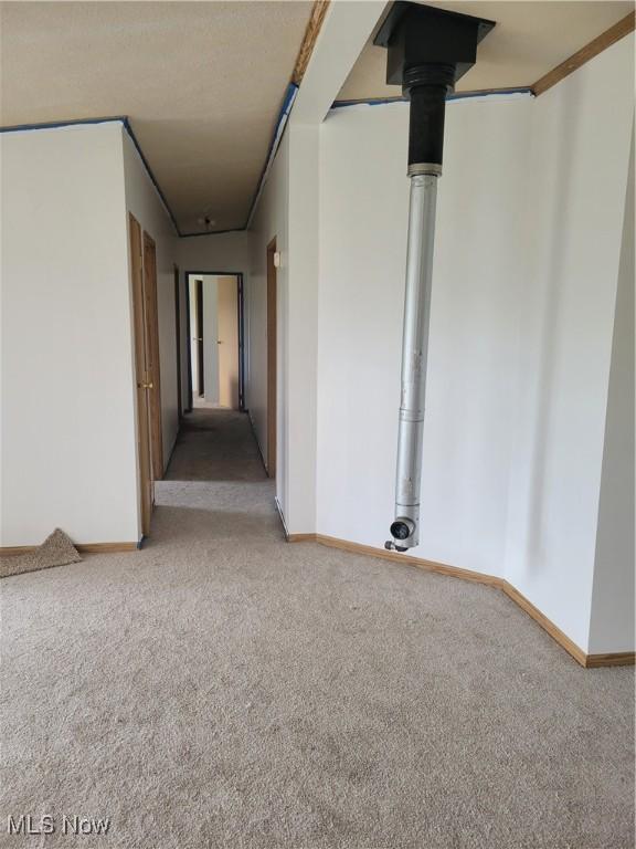 carpeted spare room featuring baseboards