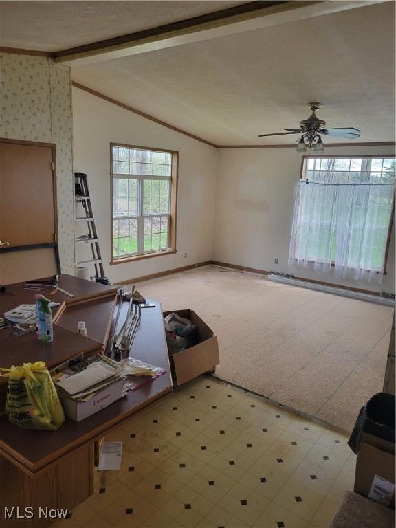 living area featuring crown molding, lofted ceiling with beams, a ceiling fan, baseboards, and light floors