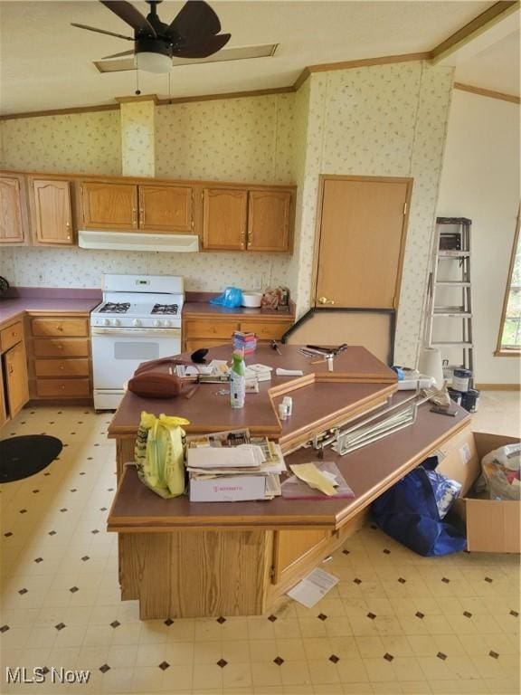 kitchen with ornamental molding, a ceiling fan, white gas range, and wallpapered walls