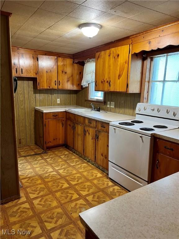 112 E College St, Alliance, OH 44601 - kitchen featuring light countertops, white electric range oven, brown cabinetry, and a sink