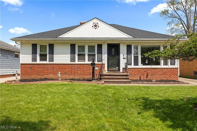 view of front facade with brick siding and a front lawn