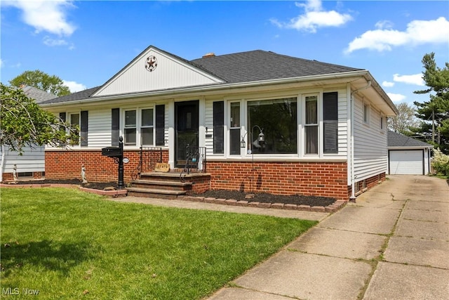 view of front of property with brick siding, a front lawn, roof with shingles, and a detached garage