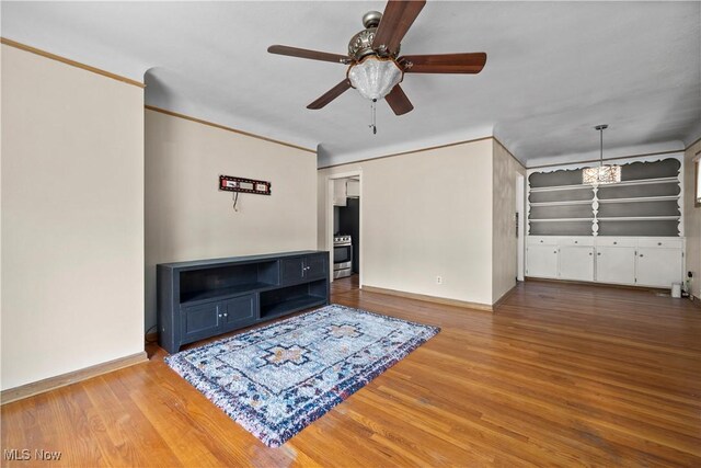 living room with baseboards, a ceiling fan, crown molding, and wood finished floors