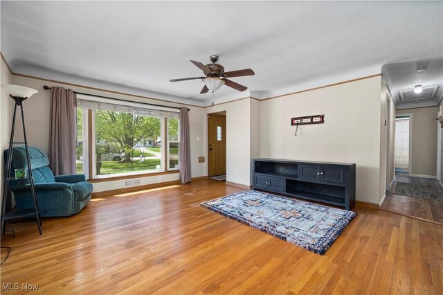 living area with visible vents, baseboards, ceiling fan, and wood finished floors