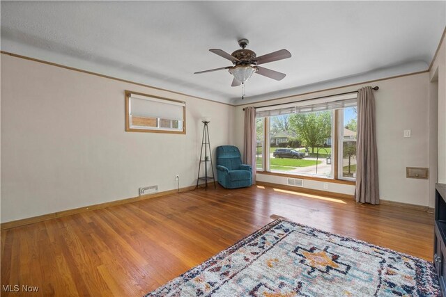 unfurnished room with baseboards, ceiling fan, visible vents, and wood finished floors