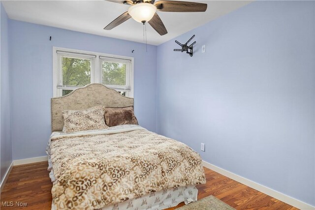 bedroom with baseboards, ceiling fan, and wood finished floors
