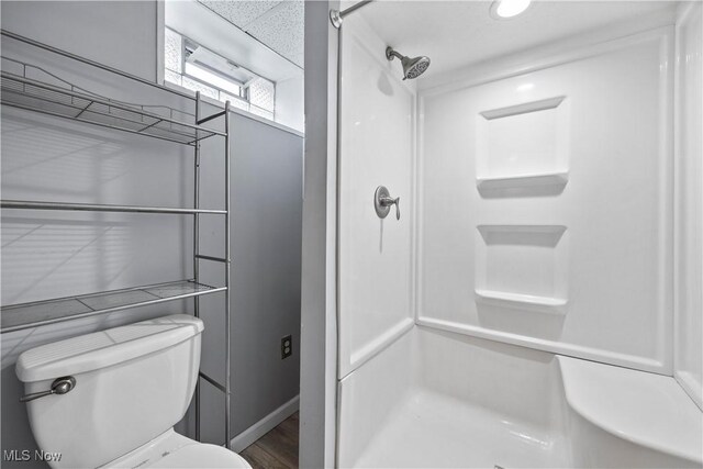 bathroom featuring toilet and walk in shower