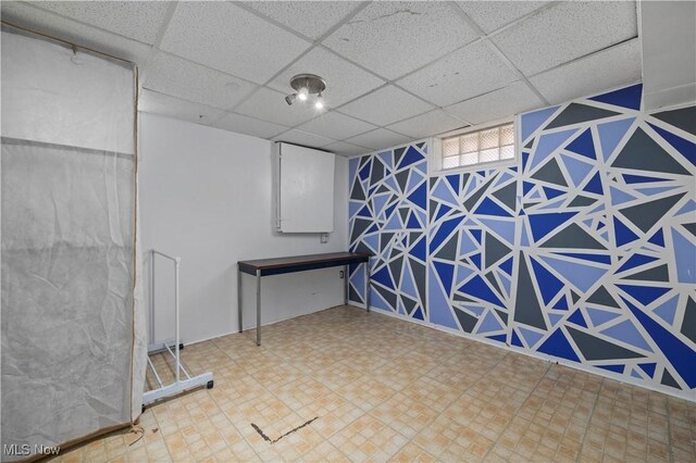 interior space featuring tile patterned floors and a drop ceiling