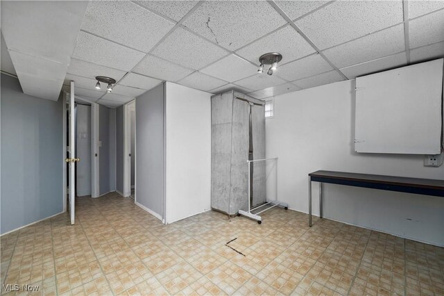 finished below grade area with tile patterned floors and a drop ceiling