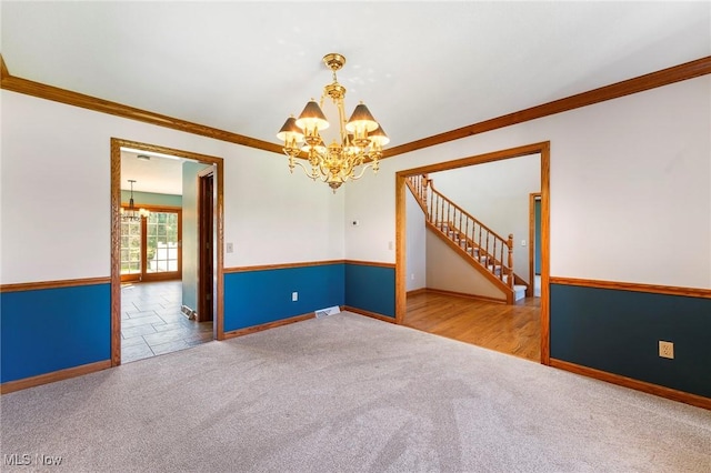 carpeted empty room with baseboards, ornamental molding, and a notable chandelier