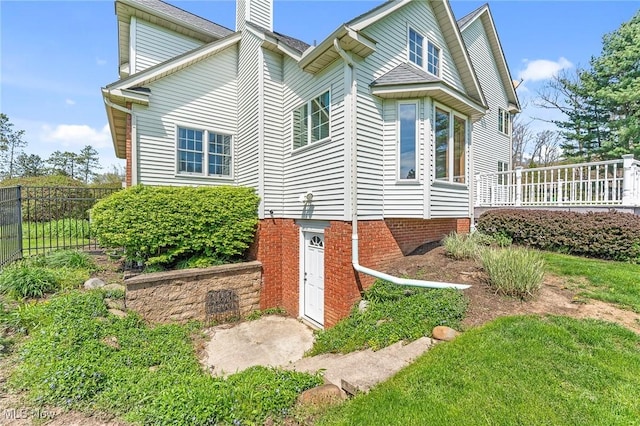 view of side of home featuring fence and a chimney