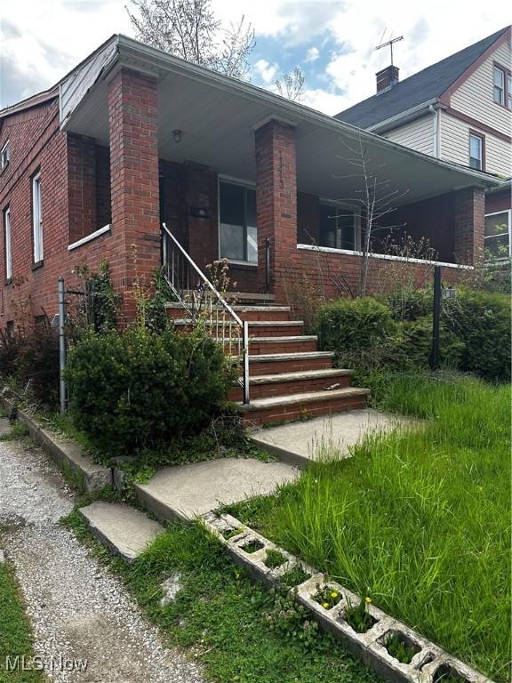 11413 Notre Dame Ave, Cleveland, OH 44104 - bungalow-style home with stairs, a porch, and brick siding