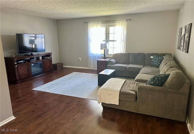 living room with dark wood-type flooring, a textured ceiling, and baseboards