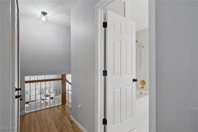 hall with baseboards and wood finished floors