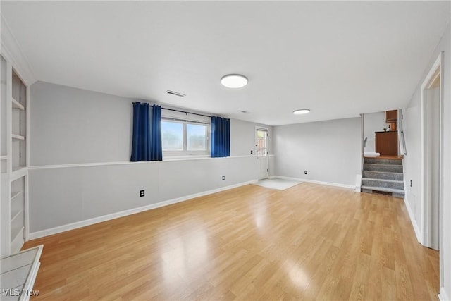 interior space featuring stairway, baseboards, light wood-type flooring, and visible vents