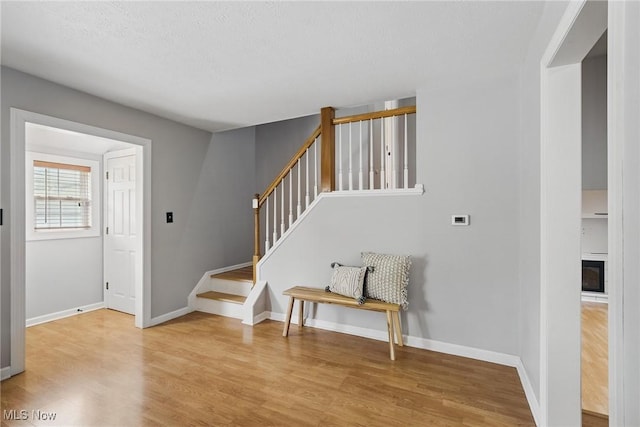 stairs with baseboards and wood finished floors